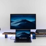 Bureau moderne avec ordinateur portable, écran, téléphone et casque