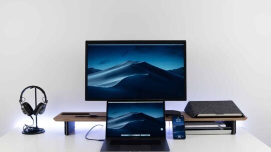 Bureau moderne avec ordinateur portable, écran, téléphone et casque