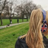 Femme écoutant de la musique avec un casque Union Jack dans un parc