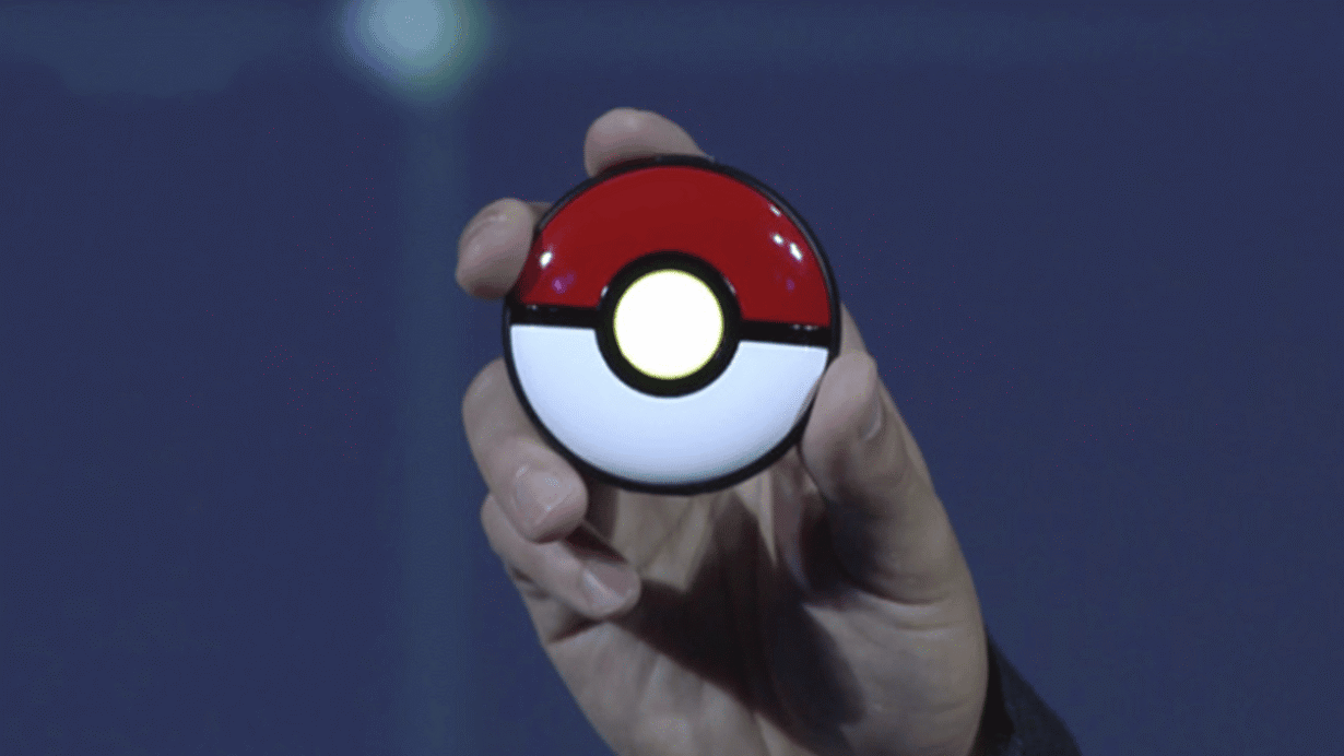 Main tenant un appareil en forme de Poké Ball