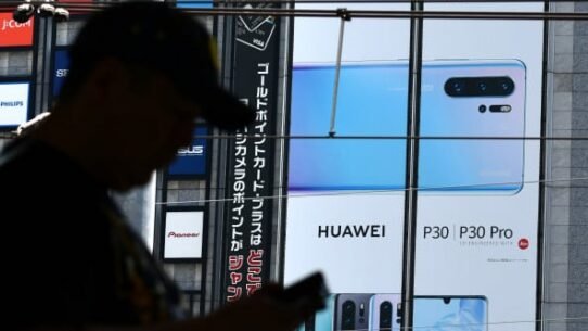 Silhouette d'une personne devant une publicité Huawei P30 Pro