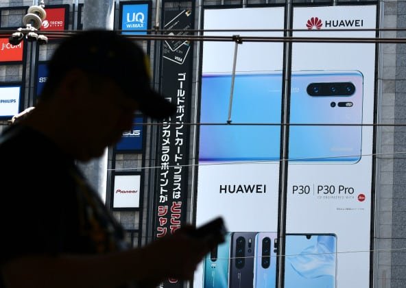 Silhouette d'une personne devant une publicité Huawei P30 Pro