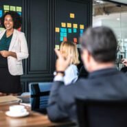 Femme présentant des idées sur un tableau de post-it en réunion