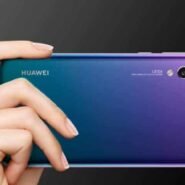 Main tenant un smartphone Huawei avec triple caméra