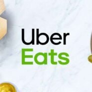Logo Uber Eats avec un burger, frites et sauces sur une table