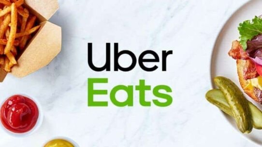 Logo Uber Eats avec un burger, frites et sauces sur une table