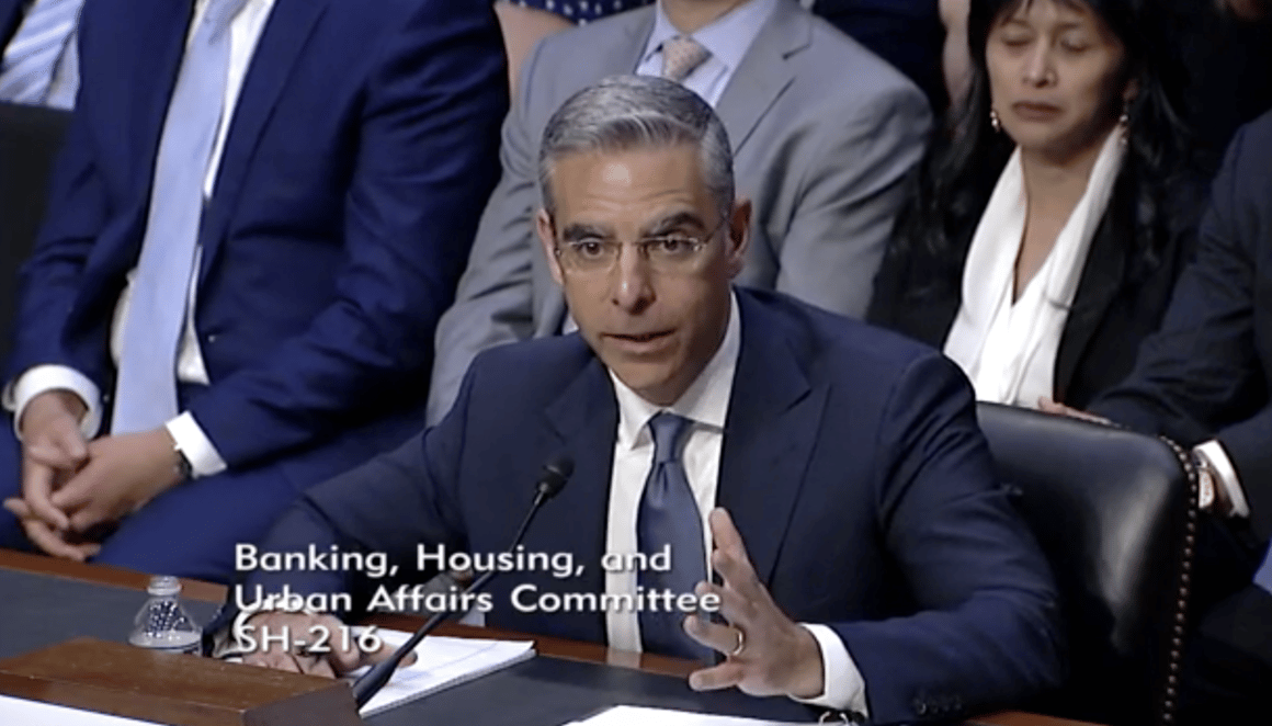 Homme en costume témoignant devant un comité au Sénat