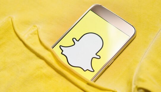 Téléphone avec logo Snapchat dans une poche jaune
