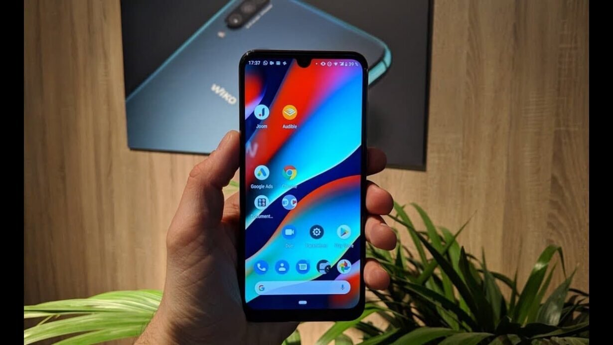 Main tenant un smartphone avec écran d'accueil coloré