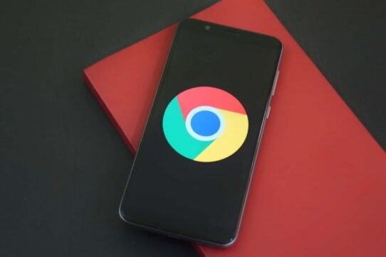 Smartphone affichant le logo de Google Chrome sur fond rouge