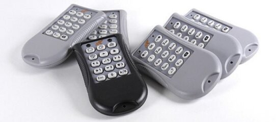 Groupe de télécommandes grises et noires posées sur une surface blanche