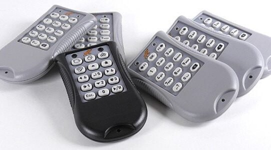 Groupe de télécommandes grises et noires posées sur une surface blanche