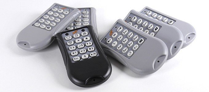 Groupe de télécommandes grises et noires posées sur une surface blanche