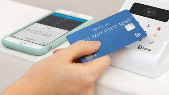 Main tenant une carte devant un terminal de paiement sans contact