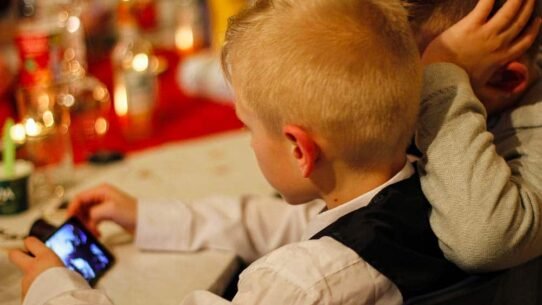 Deux enfants regardant un smartphone à une table décorée