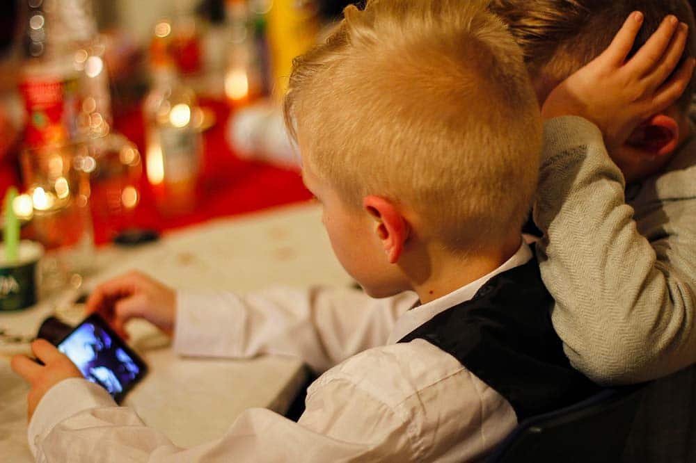Deux enfants regardant un smartphone à une table décorée