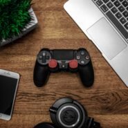 Manette de jeu, smartphone, casque et ordinateur portable sur un bureau