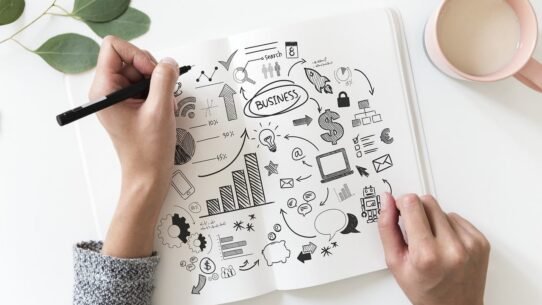 Personne dessinant un plan d'affaires sur un carnet