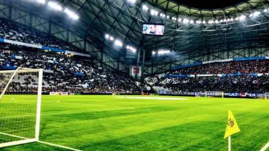 Stade rempli de spectateurs lors d'un match de football en soirée