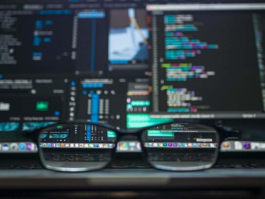 Lunettes devant un écran d'ordinateur avec du code
