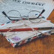 Lunettes, lettres anciennes et journal sur une table en bois