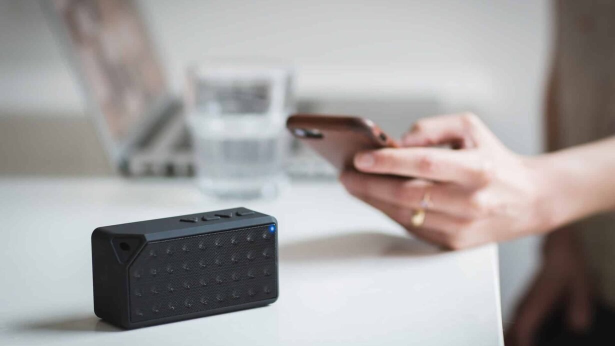 Enceinte Bluetooth avec smartphone et ordinateur en arrière-plan