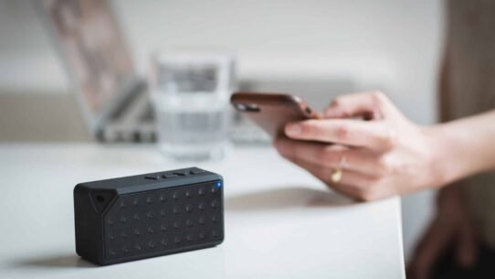 Enceinte Bluetooth avec smartphone et ordinateur en arrière-plan