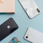 Trois smartphones posés sur une table bleue