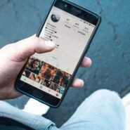 Main tenant un smartphone affichant un profil Instagram