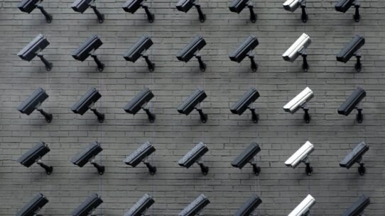 Rangée de caméras de surveillance fixées sur un mur en briques