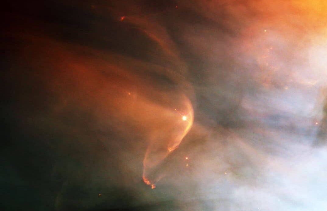 Nébuleuse orangée et bleutée éclairée par des étoiles