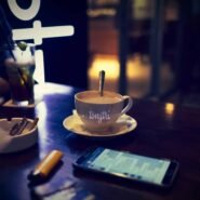 Tasse de café sur une table avec smartphone et boisson