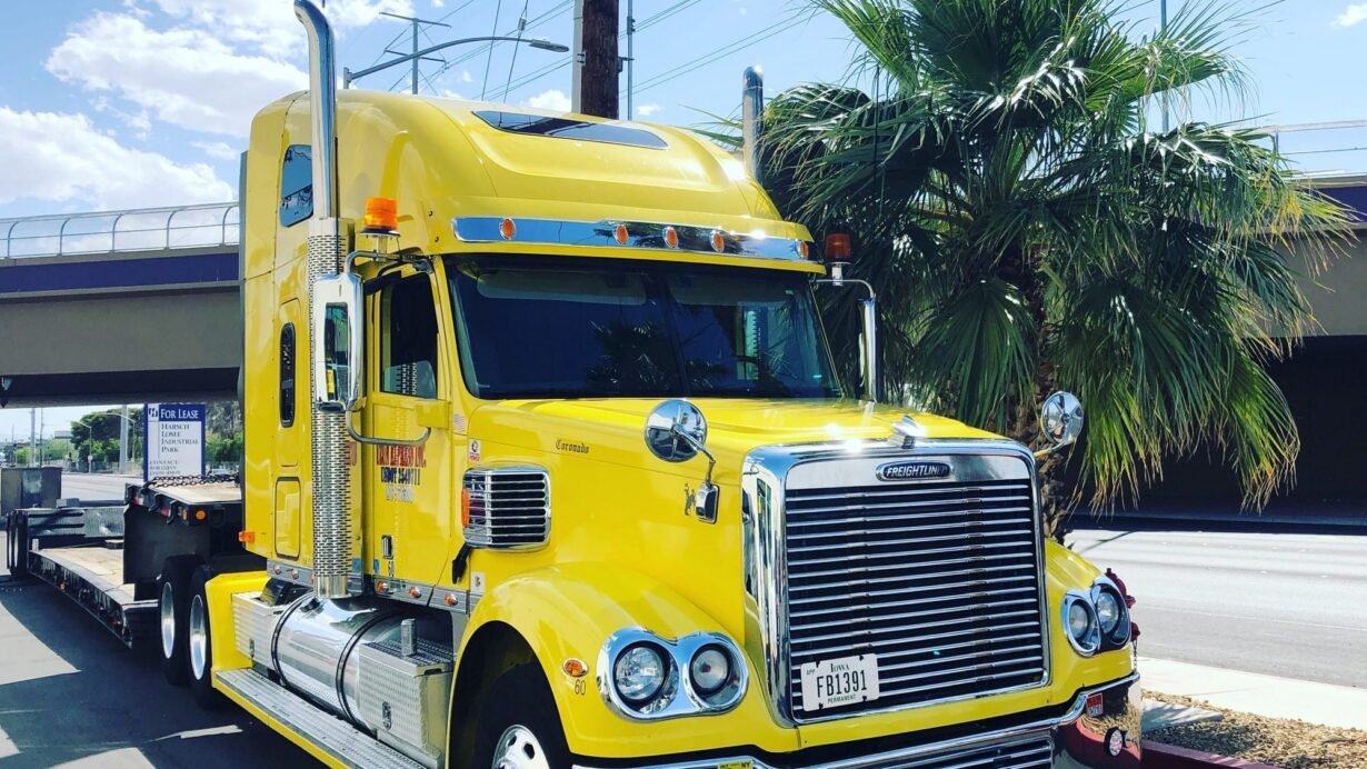 Camion jaune stationné près d'un palmier