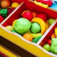 Divers jouets en forme de fruits et légumes dans un tiroir