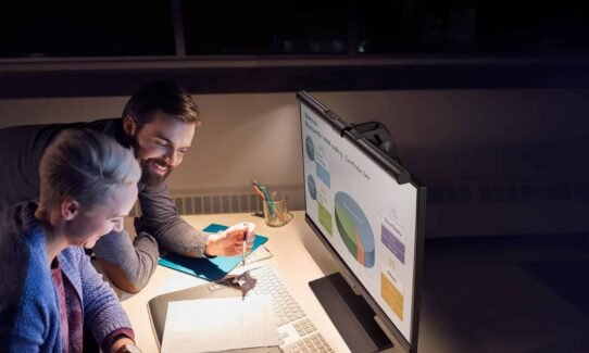 Deux personnes travaillant devant un écran avec des graphiques