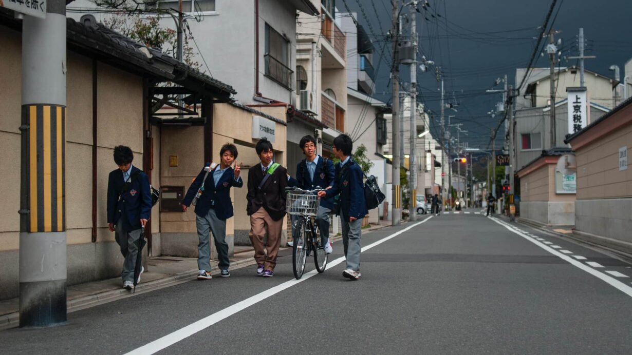 Groupe d'élèves en uniforme marchant dans une rue au Japon