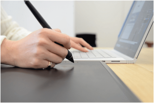 Personne utilisant une tablette graphique avec un ordinateur portable