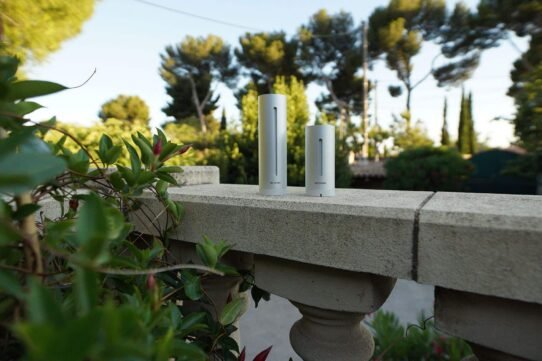 Deux stations météo sur un muret dans un jardin