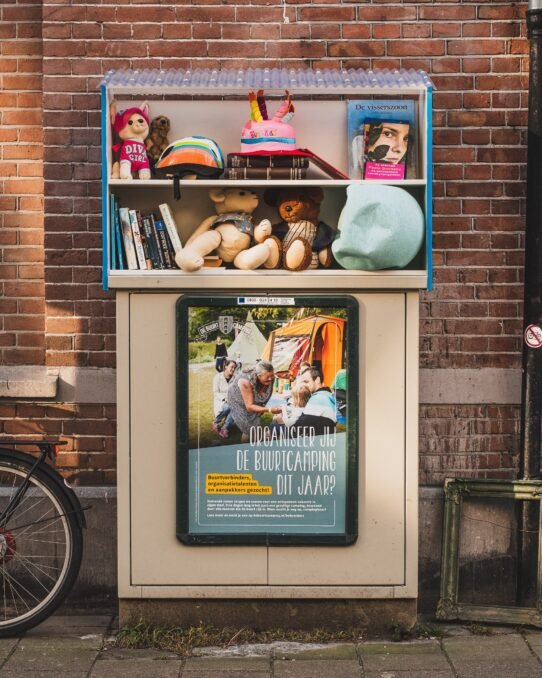 Bibliothèque de rue avec jouets et affiches de camping