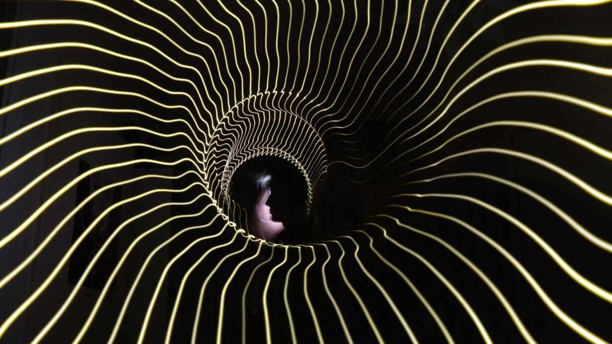 Silhouette dans un tunnel de lumière ondulée