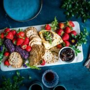 Plateau de fromages avec fruits rouges, crackers et confiture