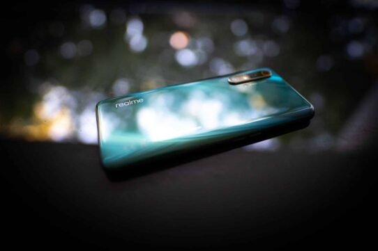 Smartphone moderne avec arrière en verre brillant sur fond flou