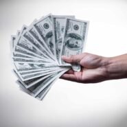 Main tenant des billets de cent dollars en éventail