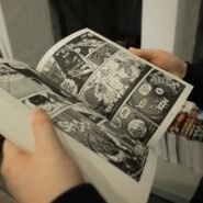 Personne feuilletant un manga en noir et blanc
