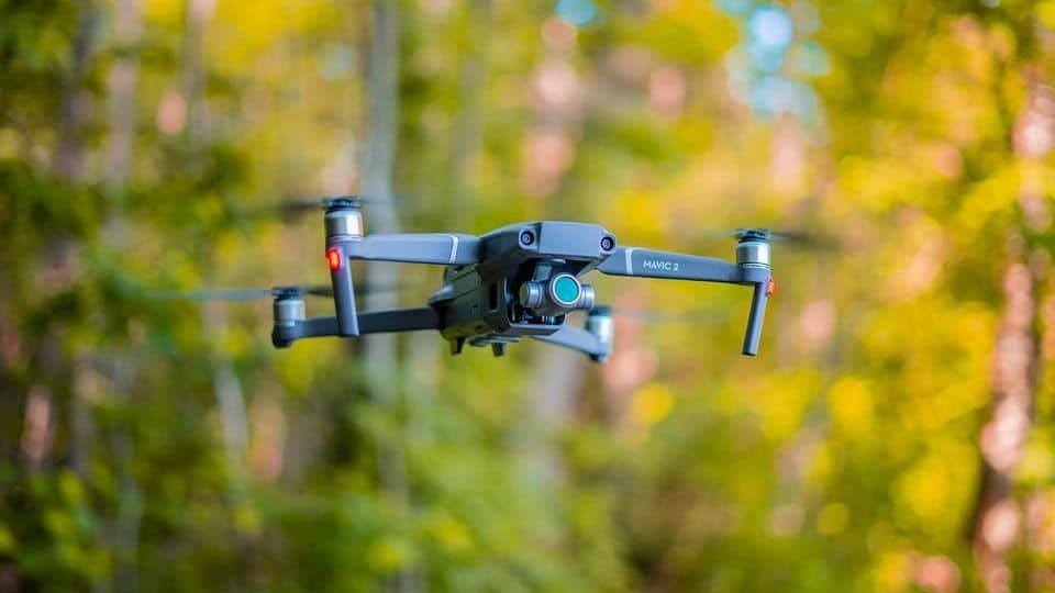 Drone en vol au-dessus d'une forêt floue en arrière-plan