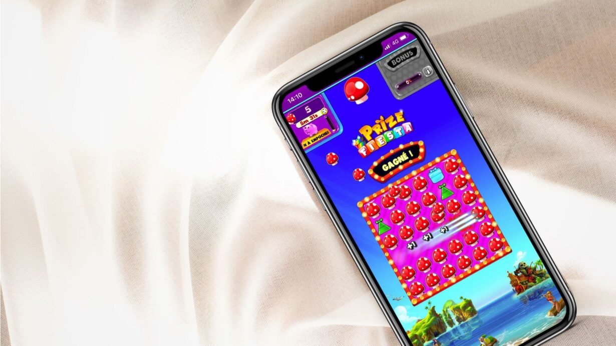 Smartphone affichant un jeu coloré sur fond de tissu clair