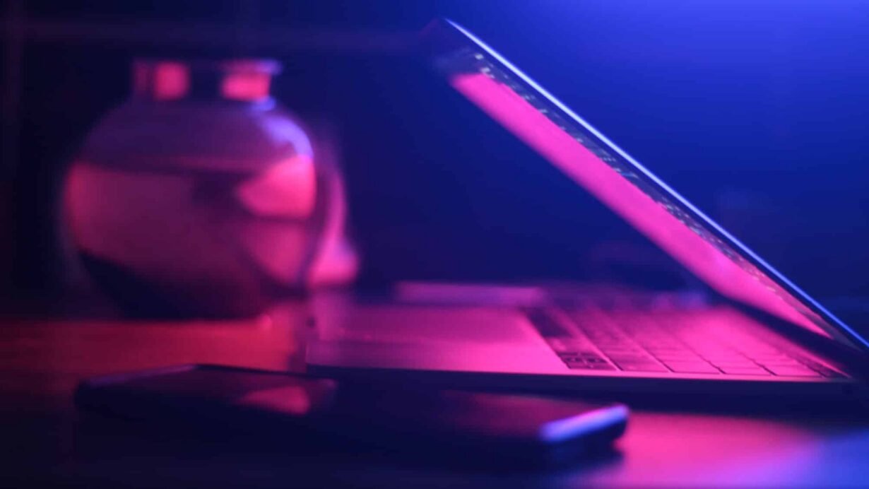 Ordinateur portable et smartphone éclairés par une lumière rose