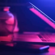 Ordinateur portable et smartphone éclairés par une lumière rose