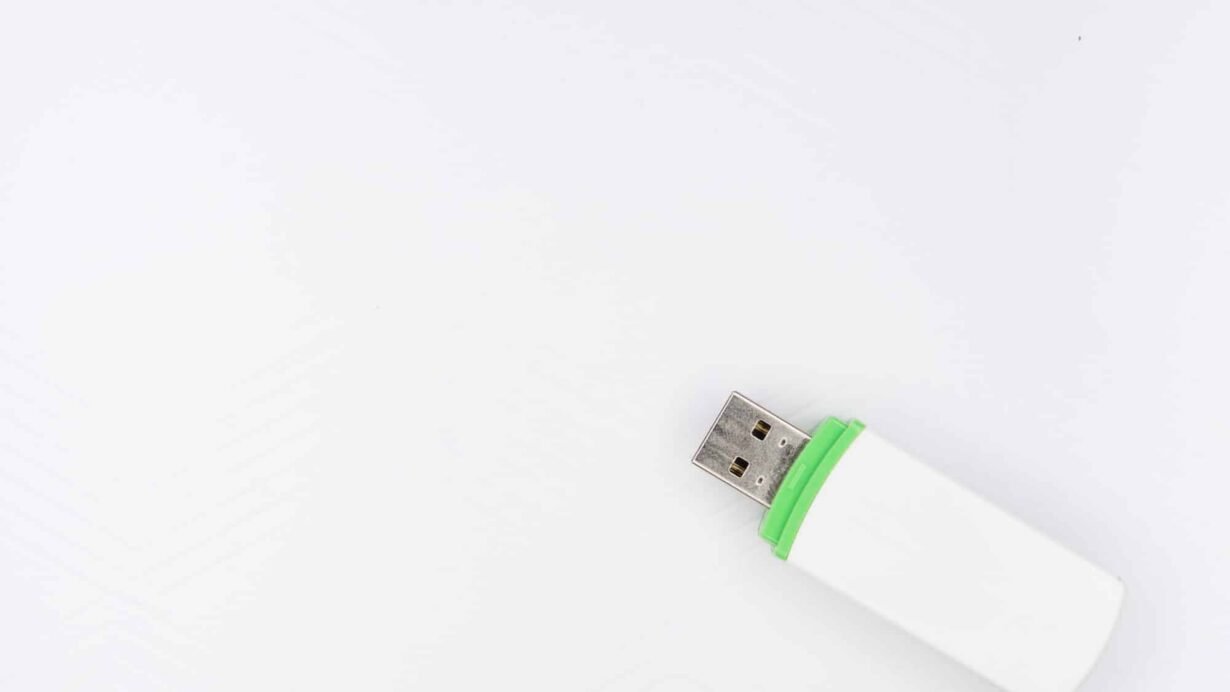Clé USB blanche avec bord vert sur fond blanc