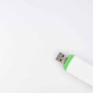 Clé USB blanche avec bord vert sur fond blanc